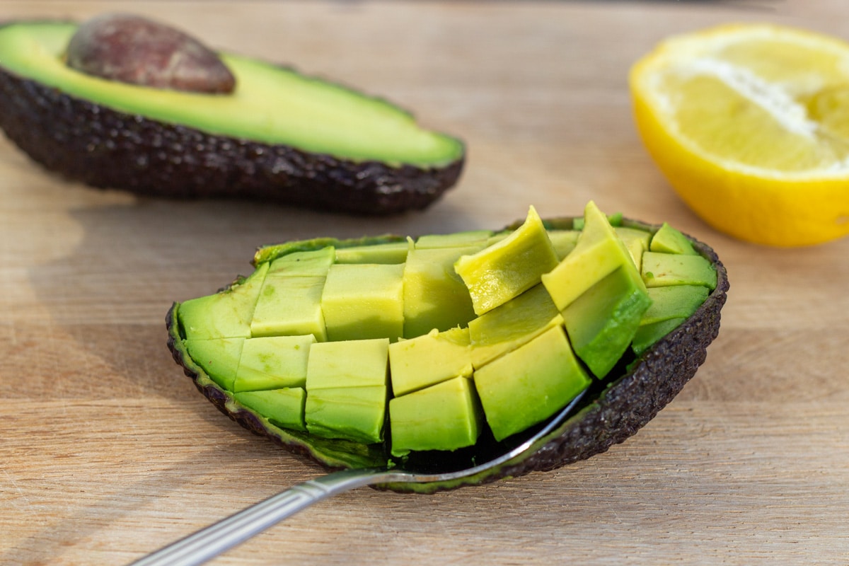 To halve avocadoer med en halv avocado skåret i tern