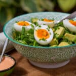 Avocadosalat med æg og lime-srirachadressing pyntet med purløg