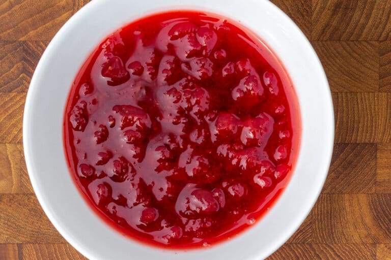 Skål med rød marmelade, der er kogt i mikrobølgeovn.