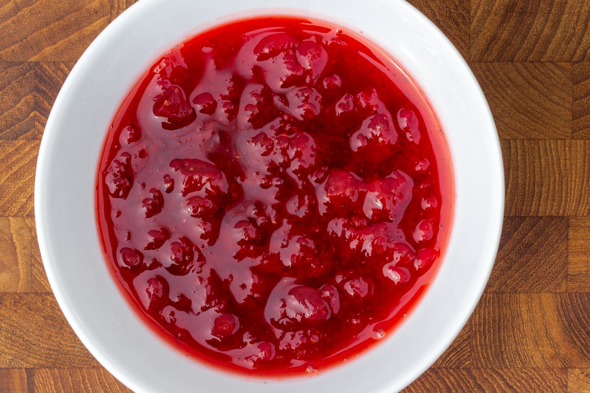 Skål med rød marmelade, der er kogt i mikrobølgeovn.
