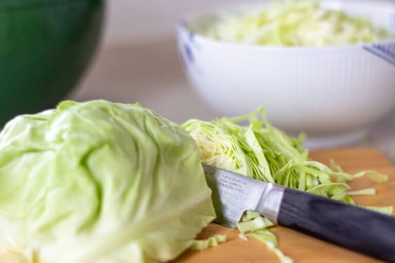 Spidskål skåret til salat og en skål med spidskålssalat