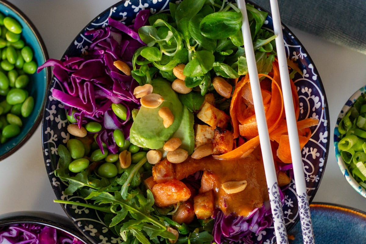 Poke bowl - skål med laks i tern, avocado, gulerod, salat, edamamebønner og peanutsauce