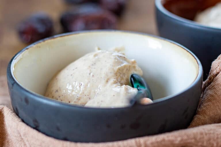 Proteinis med hytteost og dadler – cremet sundere dessert med højt proteinindhold serveret i en skål.