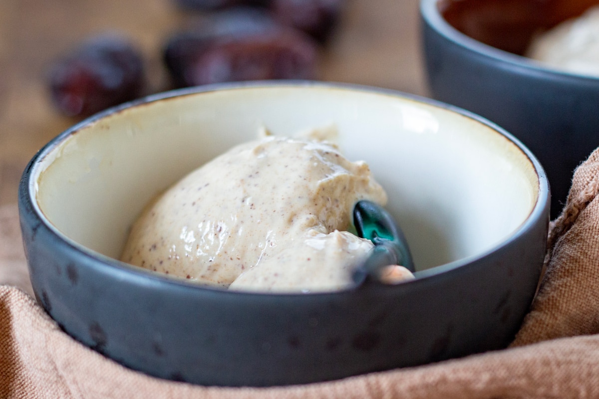 Proteinis med hytteost og dadler – cremet sundere dessert med højt proteinindhold serveret i en skål.