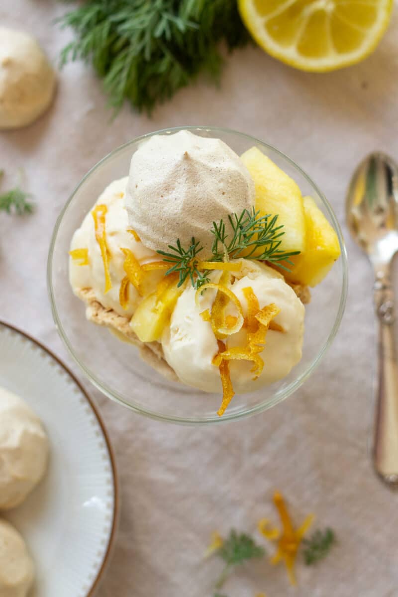 Cola mess dessert anrettet i glas med ananas, colais, colamarengs og kandiserede citronstrimler