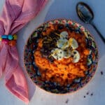 Energigrød med gulerod pyntet med banan, appelsinskal, kakaonibs og nøddecreme