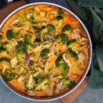 Små stykker kylling i en pande med broccoli, squash og rødløg i flødesovs med paprika og estragon.