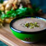 Dressing med syltede jalapenos og paprika foran en burger.