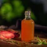 En flaske med bearnaiseessens af hvidvin og hvidvinseddike med skalotteløg og estragon