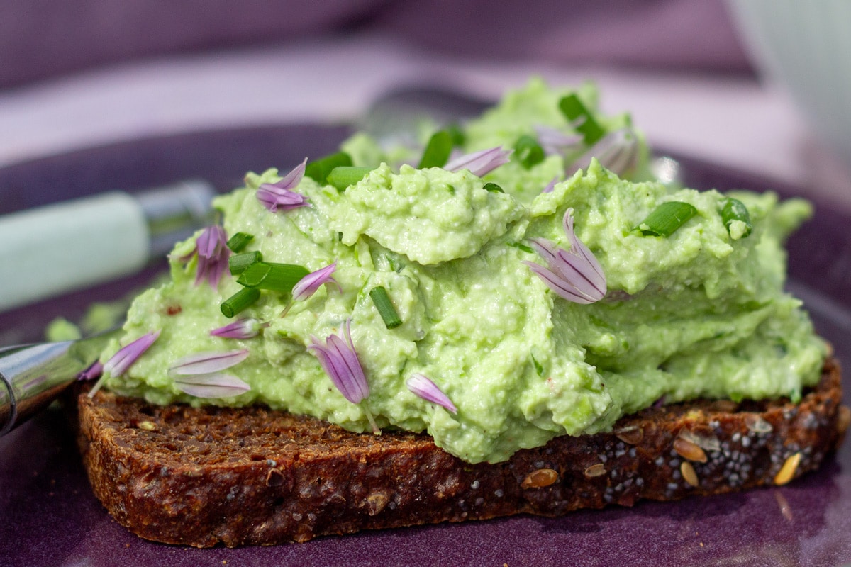 Avocadocreme med edamamebønner, hytteost og purløg på rugbrød som pålæg.