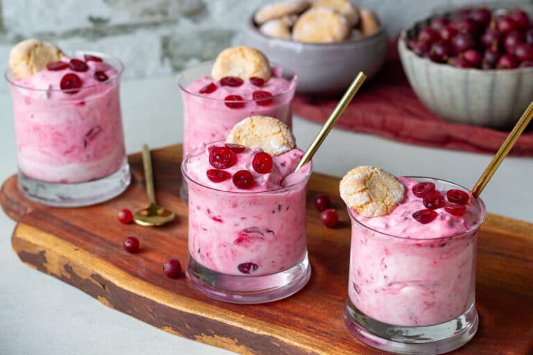 Gooseberry fool rørt med hyldeblomstsaft og stikkelsbær og mandelkager på toppen